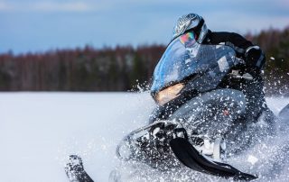 Snowmobile kicking up snow.