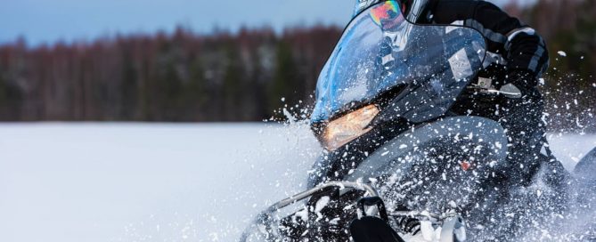 Snowmobile kicking up snow.