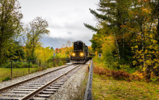 A train surrounded by fall foliage on the Adirondack Scenic Railroad