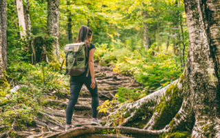 A woman hiking in a forest at Brewster Peninsula Nature Trails