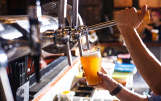 A bartender pouring beer at one of Lake Placid's many breweries