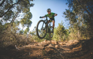 A man catches air while mountain biking on the trails surrounding Lake Placid