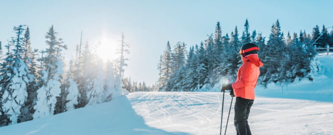 A woman skiing on a snow covered mountain during spring break in Lake Placid