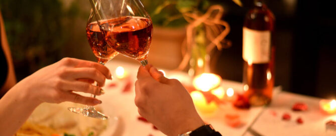 A man and woman clink classes at a romantic dining experience in Lake Placid