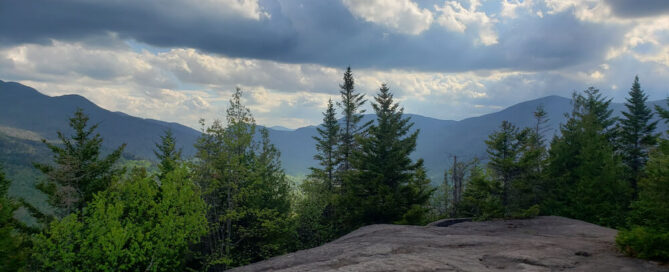 A scenic view of Adirondack mountains and towering trees on a hike near Lake Placid